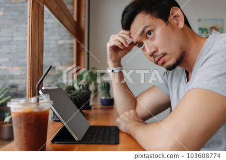Serious freelance man working in the cafe with his tablet computer. 103608774