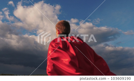 child boy son kid superhero plays park sunset red cape wind. childhood dream happy family wind. cheerful superhero, victory, fantasy power fight, child superhero portrait, smile mood, green field 103609190