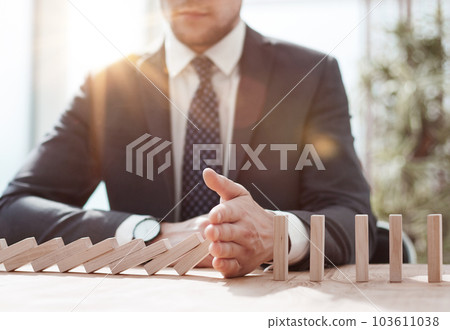 Businessman with dominoes in the office. concept business risk Businessman with dominoes in the office. concept business risk 103611038