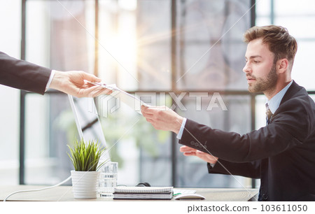 Close Up Of Businessman Taking Folders From Hand 103611050