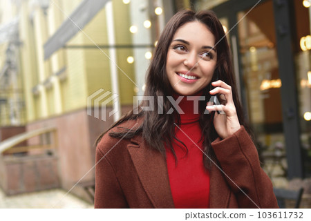Young woman smiles while talking on her smart phone. 103611732