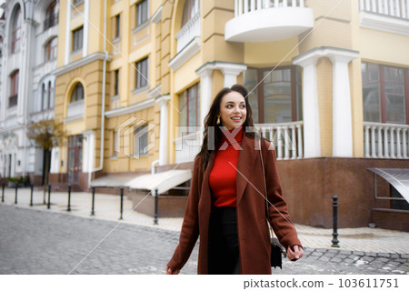 A smiling stylish woman crosses the road in the street. good day A smiling stylish woman crosses the road in the street. good day 103611751