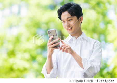A young businessman refreshingly walking in an off-jacket A young businessman refreshingly walking in an off-jacket 103612836