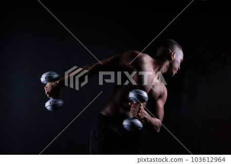 Athletic african american man topless, big muscles, dark background studio Athletic african american man topless, big muscles, dark background studio 103612964