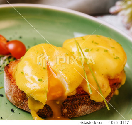 Classic egg benedict on green plate Classic egg benedict on green plate 103613167