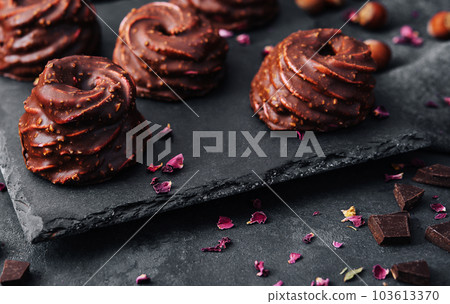 cakes in chocolate glaze on stone board 103613370