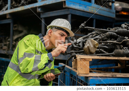 Engineering man worker wear uniform and helmet using tablet checking automotive parts in warehouse. 103613515