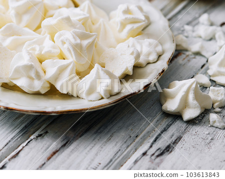 Meringue cookies in in a plate on wood 103613843