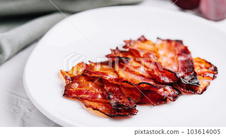 Plate with tasty bacon slices on stone 103614005