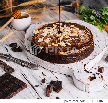 Cocoa brownies pouring with melted dark chocolate Cocoa brownies pouring with melted dark chocolate 103614079