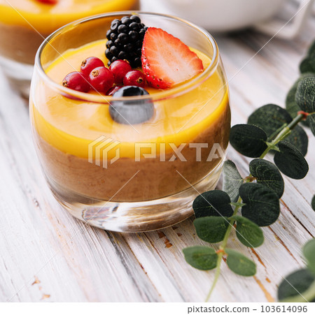 Delicious panna cotta with mango with berries 103614096