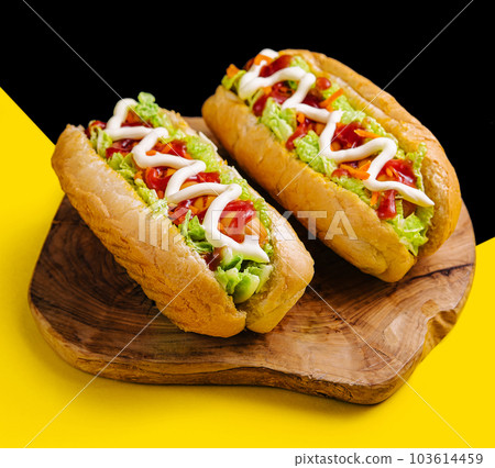 Two delicious hotdogs on wooden board 103614459