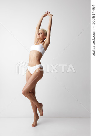 Full-length portrait of young, tender, beautiful woman with slim, fit body shape, posing in underwear against grey studio background Full-length portrait of young, tender, beautiful woman with slim, fit body shape, posing in underwear against grey studio background 103614464