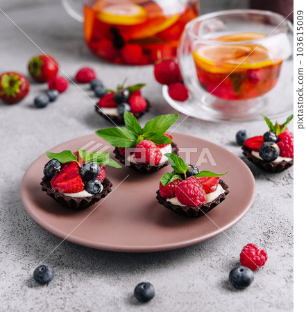 Chocolate ganache tarts with fresh berries 103615009