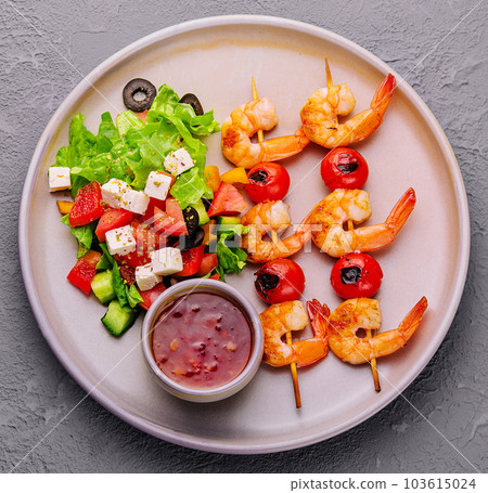 Gourmet shrimp skewers with salad greens and sauce Gourmet shrimp skewers with salad greens and sauce 103615024