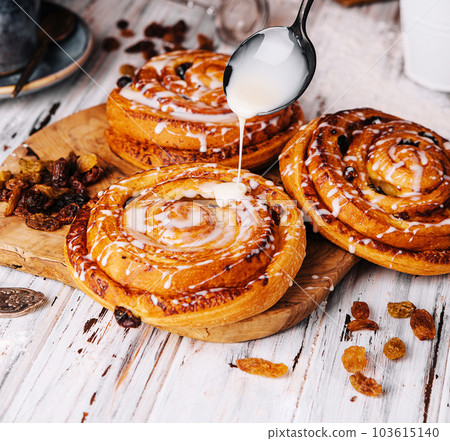 Homemade raisin roll pastry with vanilla icing Homemade raisin roll pastry with vanilla icing 103615140