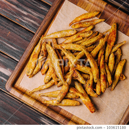 wooden board of fried whitebait with slices of lemon wooden board of fried whitebait with slices of lemon 103615180