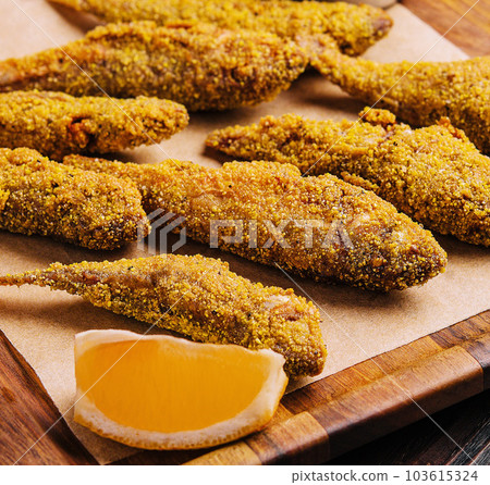 Fried smelt on a wooden chopping board Fried smelt on a wooden chopping board 103615324