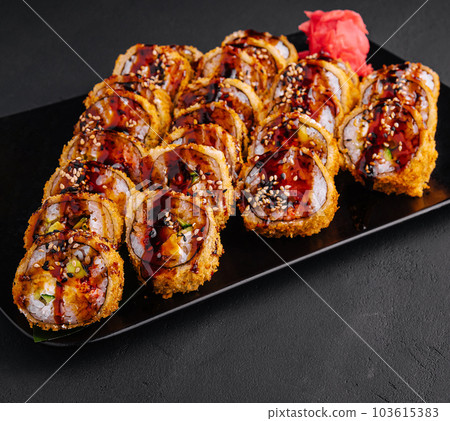 Served warm sushi with ginger and wasabi on a black stone plate 103615383