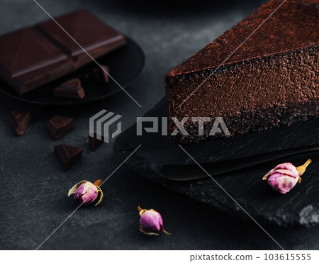 Chocolate cheesecake on black stone board Chocolate cheesecake on black stone board 103615555