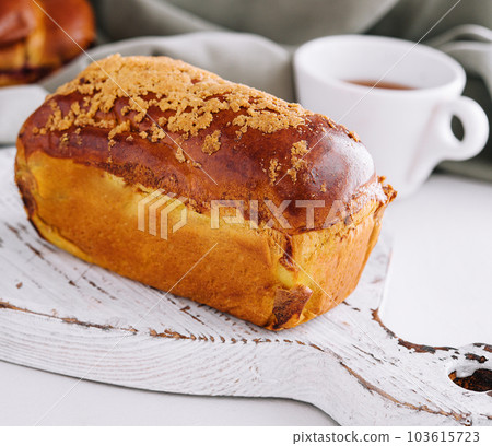 Delicious baked bun on white wood Delicious baked bun on white wood 103615723
