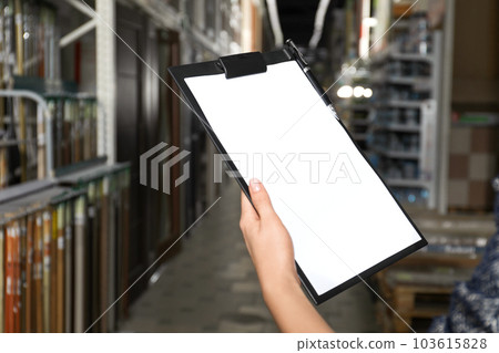 Woman with clipboard in wholesale warehouse, closeup. Space for text Woman with clipboard in wholesale warehouse, closeup. Space for text 103615828