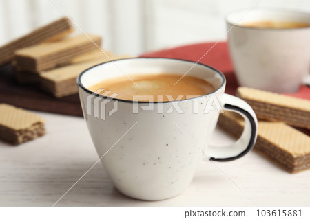 Delicious coffee and wafers for breakfast on white wooden table 103615881