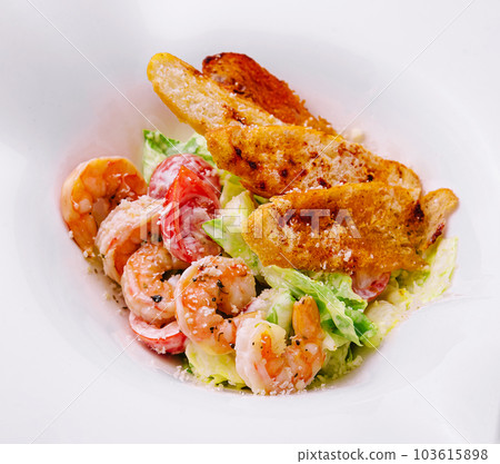 lettuce salad with Caesar sauce, tiger prawns, cheese and bread crumbs lettuce salad with Caesar sauce, tiger prawns, cheese and bread crumbs 103615898