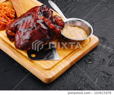 Tasty baked pork knuckle on wooden board 103615976