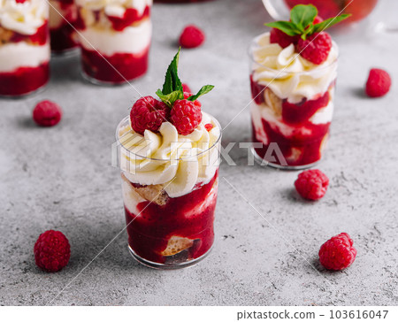 Layered dessert Trifle with vanilla cake, whipped cream and fresh raspberries 103616047