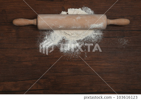 Flour and rolling pin on wooden table, top view. Space for text Flour and rolling pin on wooden table, top view. Space for text 103616123