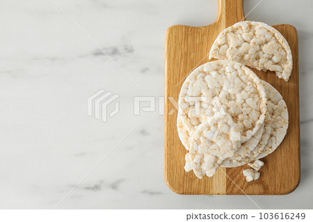 Puffed rice cakes on white wooden table, top view. Space for text 103616249