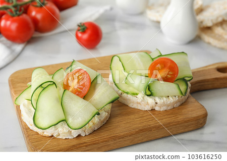 Puffed rice cakes with vegetables on white marble table 103616250