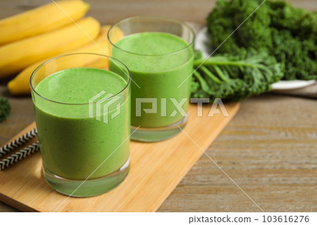 Tasty fresh kale smoothie on wooden table, closeup 103616276