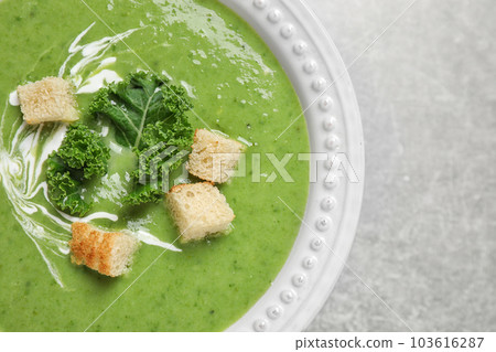 Tasty kale soup with croutons on grey table, top view Tasty kale soup with croutons on grey table, top view 103616287