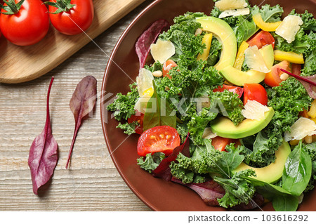 Tasty fresh kale salad on wooden table, flat lay 103616292