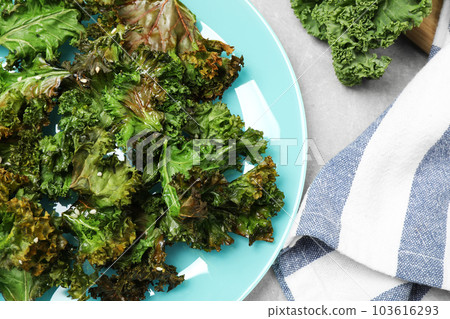 Tasty baked kale chips on light grey table, flat lay 103616293