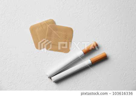Nicotine patches and cigarettes on white background, flat lay Nicotine patches and cigarettes on white background, flat lay 103616336