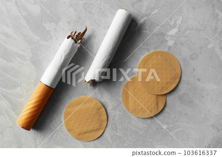 Nicotine patches and broken cigarettes on grey table, flat lay 103616337