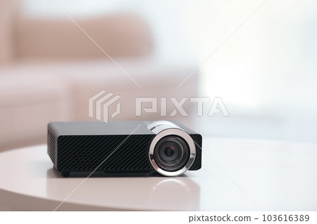 Modern video projector on white table indoors Modern video projector on white table indoors 103616389