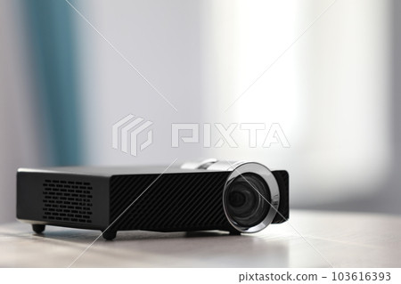 Modern video projector on white table indoors. Space for text 103616393