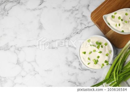 Fresh sour cream with onion on white marble table, flat lay. Space for text 103616584