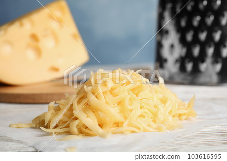 Tasty grated cheese on white wooden table, closeup 103616595