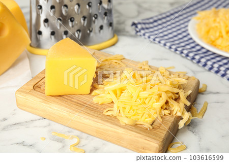 Delicious grated cheese on white marble table 103616599