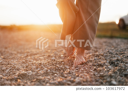 Close up of womans barefoot feet walking on rock beach. Close up of womans barefoot feet walking on rock beach. 103617972