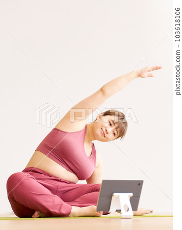 胖乎乎的年輕女子邊看平板電腦邊做瑜伽加上尺寸模型圖像 胖乎乎的年輕女子邊看平板電腦邊做瑜伽加上尺寸模型圖像 103618106