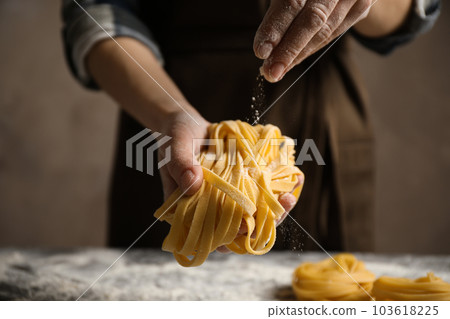 Woman holding pasta on brown background, closeup Woman holding pasta on brown background, closeup 103618225