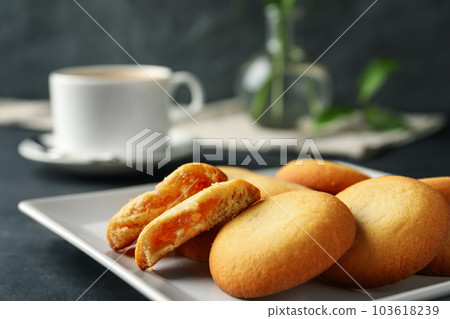 Tasty shortbread cookies with filling on black table, closeup 103618239