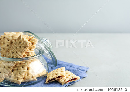 Tasty cookies with filling on light grey table. Space for text 103618240