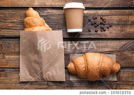 Tasty croissants and coffee on wooden table, flat lay Tasty croissants and coffee on wooden table, flat lay 103618358